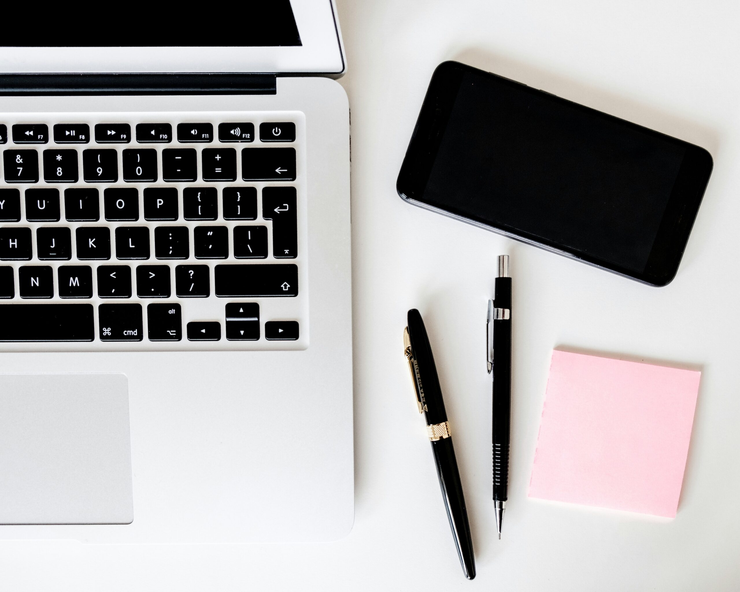 Two pens near MacBook Air, symbolizing a creative workspace.